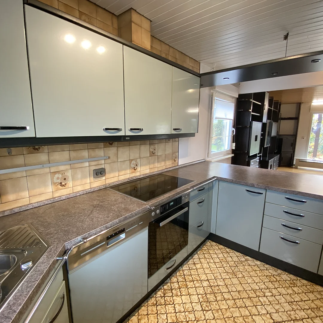 Einfamilienhaus Appenheim Ingelheimer Straße Küche Moderne Küche mit grauen Arbeitsflächen, hellblauen Unterschränken, weißen Oberschränken und eingebautem Herd mit Cerankochfeld.